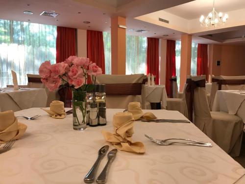 uma mesa com um vaso de flores cor-de-rosa em Hotel & SPA Otdih em Kavarna