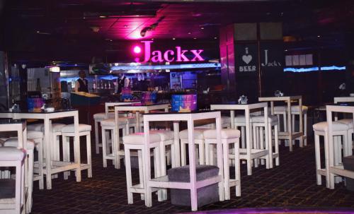 a bar with white tables and white stools at Romance Alexandria Hotel in Alexandria