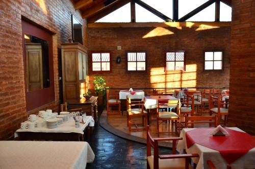 a restaurant with tables and chairs in a brick building at Posada Alpenrose Neu in Villa Carlos Paz