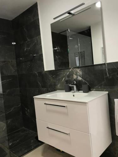 a bathroom with a white sink and a mirror at Loft Infinity in Petrovac na Moru