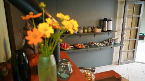 a vase filled with yellow and orange flowers on a counter at Pousada Do Capitão in Florianópolis