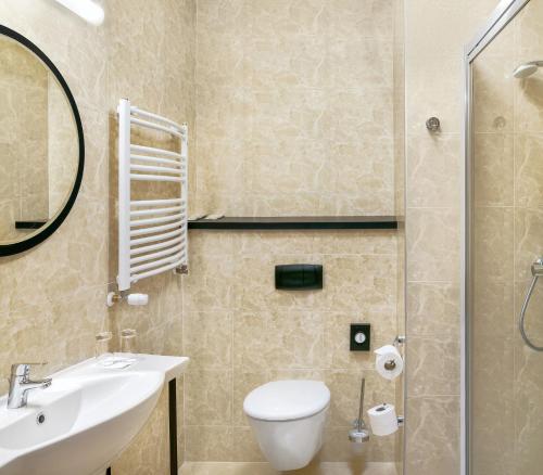 een badkamer met een toilet, een wastafel en een douche bij Metropolo by Golden Tulip Krakow in Krakau