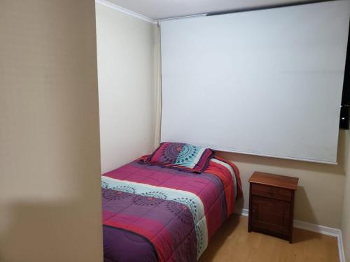 Dormitorio pequeño con cama pequeña y mesa en Cuatro Norte 955 Apartamento Full equipado, en Talca
