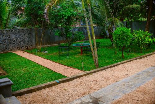a garden with a table and a tree in it at Thambu Illam in Jaffna