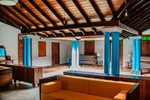 a living room with blue columns and a couch at Thambu Illam in Jaffna