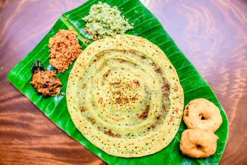 a green plate of food on top of a banana leaf at Thambu Illam in Jaffna