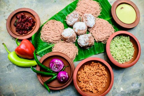 a bunch of food on a green leaf at Thambu Illam in Jaffna
