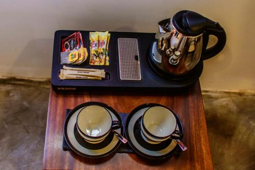 a tray with a tea pot and cups on a table at Thambu Illam in Jaffna