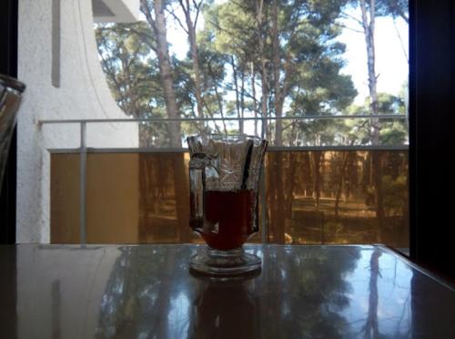 a glass cup sitting on a glass table at HOTEL CHELIA in Batna