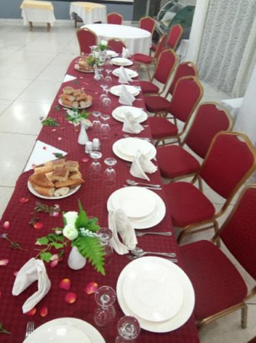 a long table with white plates and napkins on it at HOTEL CHELIA in Batna