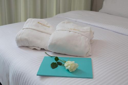 a bed with two towels and a blue plate with a rose at Suite Caesar - Neot Golf in Caesarea