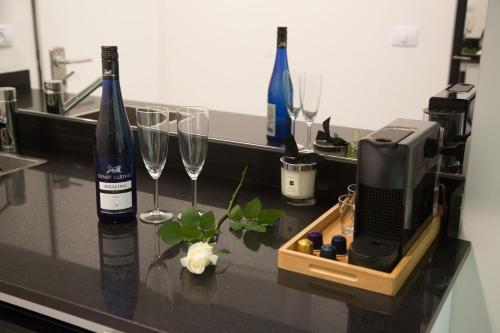 a counter with two bottles and a television and wine glasses at Suite Caesar - Neot Golf in Caesarea