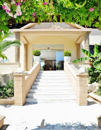 a staircase leading up to a building with flowers at Olive Garden Hotel in Lardos
