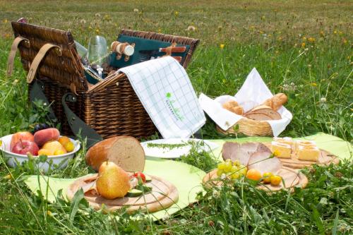 a picnic with baskets of fruit and bread on the grass at Landhotel Gafringwirt in Euratsfeld