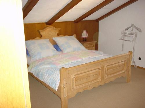 um quarto com uma cama de madeira e almofadas azuis em Ferienwohnung Späth em Neuschönau