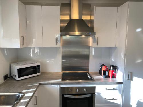 a kitchen with white cabinets and a stove top oven at Glenelg Street in Perth