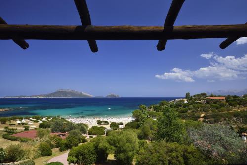 a view of the beach from a window at VOI Colonna Village in Golfo Aranci