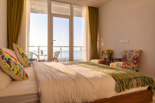 - une chambre avec un grand lit et une grande fenêtre dans l'établissement Sunrise Villas, à Al Sharqiyah