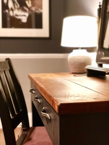 a wooden desk with a lamp and a chair at Jardine Apartment @ Cairn Dhu House in Stornoway