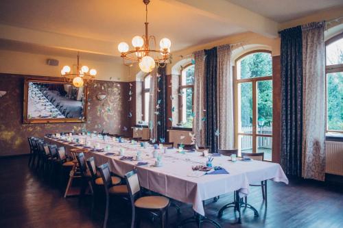 a long dining room with a long table and chairs at Jägerhof Putzkau in Putzkau