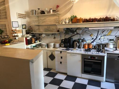 a kitchen with white appliances and a checkered floor at Le Flamant Rouge Guesthouse in Peyriac-de-Mer