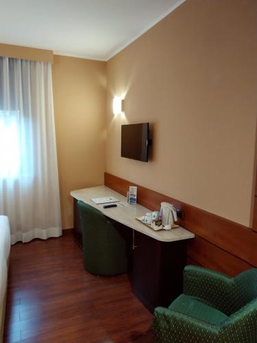 a hotel room with a desk and two chairs at Hotel Mirage Sure Hotel Collection by Best Western in Milan