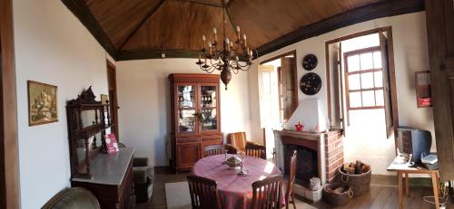 ein Esszimmer mit einem Tisch und einem Kamin in der Unterkunft Casa Dos Strecht's in Castelo de Paiva