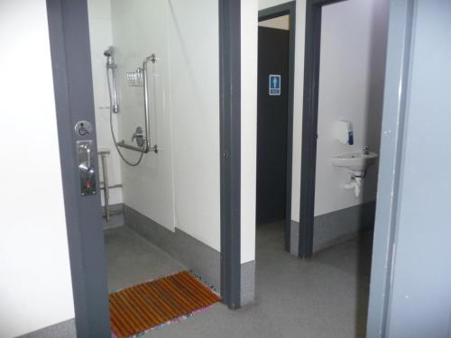 a bathroom with a shower stall and a sink at Mount Backpackers in Mount Maunganui