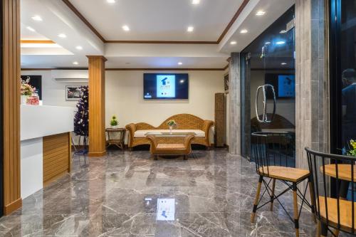 a lobby with a waiting room with a table and chairs at Suthep Home & Hostel in Bangkok