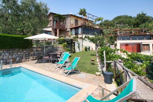 una casa con piscina con sedie e ombrellone di The Sea Farmhouse a Sorrento