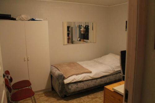 um pequeno quarto com uma cama e um espelho em Kassie & Gia's Home em Vestnanhavn