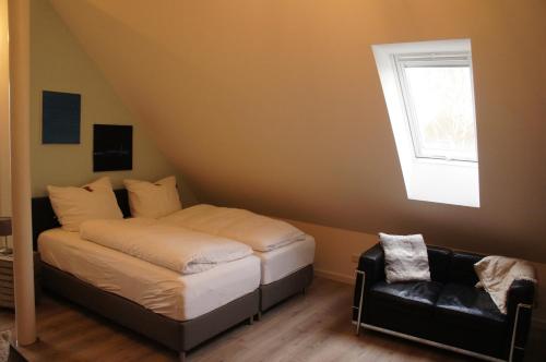1 dormitorio con 1 cama, 1 silla y 1 ventana en Dachstudio Bisping33, en Ascheberg
