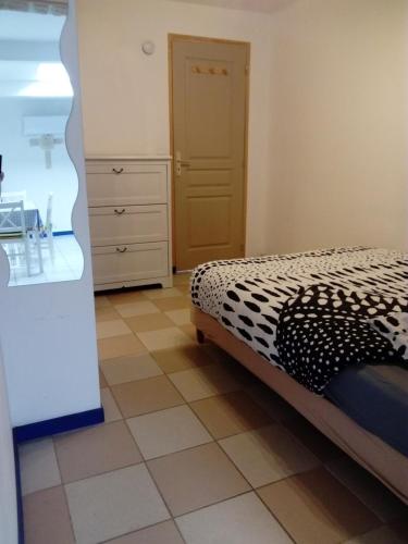 a bedroom with a bed and a tiled floor at Studio des Grenadiers in Balaruc-les-Bains