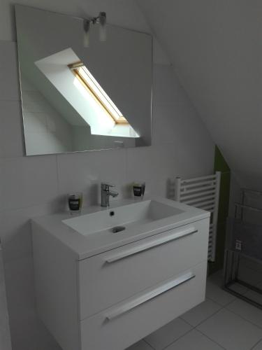 une salle de bain avec un lavabo blanc et un miroir dans l'établissement Villa Métisse Ile et Villas Groix, à Groix
