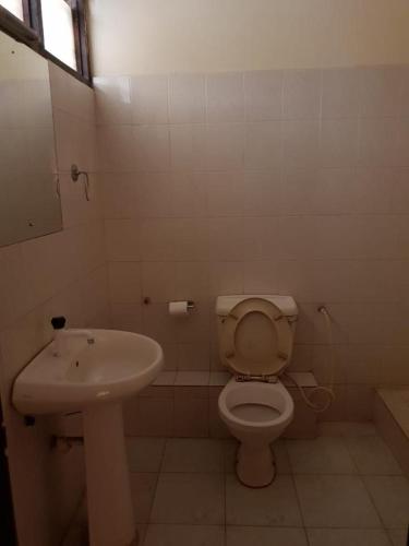 a bathroom with a toilet and a sink at Surahi Restaurant & Guest House in Malindi