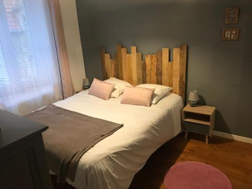 una camera da letto con un letto grande con testiera in legno di Comme à la maison a Boulogne-sur-Mer