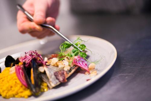 a person eating a plate of food on a table at Hotel Aubrecht Country Spa Resort in Przechlewo