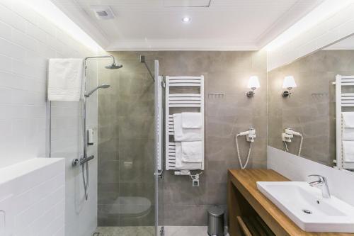uma casa de banho com um chuveiro e um lavatório. em Hotel Aubrecht Country Spa Resort em Przechlewo