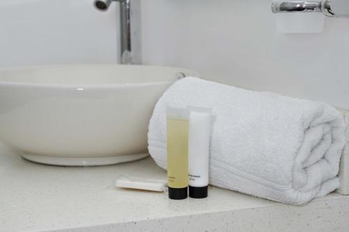 バランキージャにあるHotel Casa Nicoのバスルーム(シンク、タオル、歯磨き粉付)