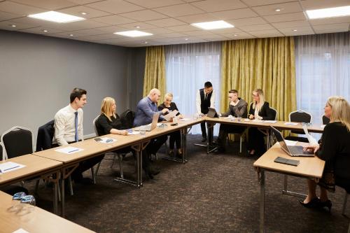 a group of people sitting at a table in a room at Novotel Wolverhampton City Centre in Wolverhampton