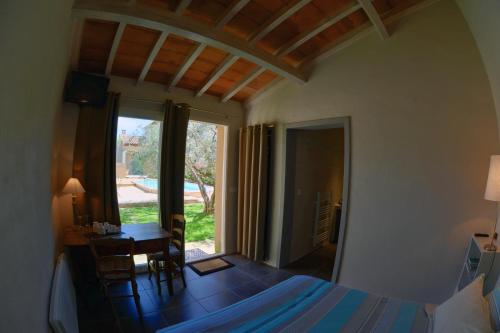 um quarto com uma cama, uma secretária e uma janela em L'Olivette em Montagnac