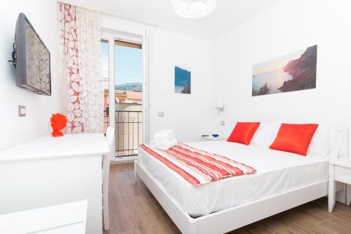 Habitación blanca con cama y ventana en Coast & Coast | Apartments, en Piano di Sorrento