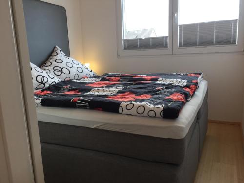 a bed with a quilt on it in a bedroom at Ferienwohnung Haag in Uhldingen-Mühlhofen