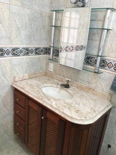 a bathroom with a sink and a mirror at Casa Temporada Saquarema in Saquarema
