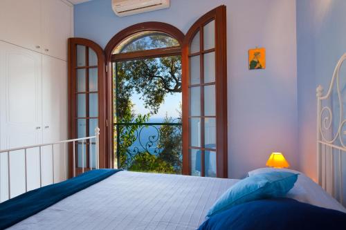 ein Schlafzimmer mit einem Bett und einem großen Fenster in der Unterkunft Casa Marea in Conca dei Marini