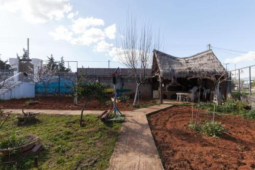 a house with a thatched roof in a garden at Country Rooms near Athens - Airport in Vravrona