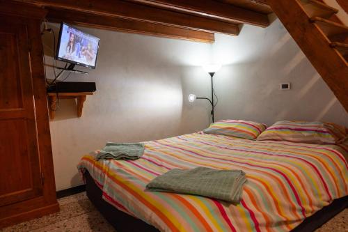 a bedroom with a bed with a tv on the wall at Due Papi in Savona