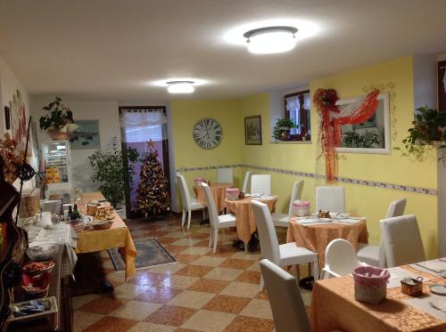 un restaurante con mesas y sillas y un reloj en la pared en G&G Bed&Breakfast and apartments, en Garda