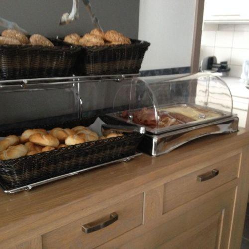a counter with baskets of bread and pastries on it at Hédervári Lovas Vendégház in Hédervár