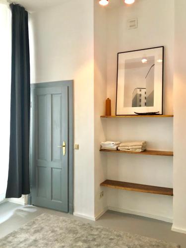 a hallway with a blue door and a mirror at Ladenwohnung in Kreuzberg mit Parkplatz in einer Tiefgarage in Berlin